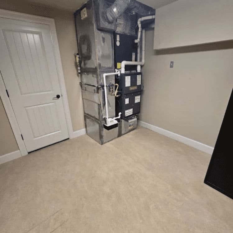 Basement with HVAC system and door; clean, neutral walls and flooring.