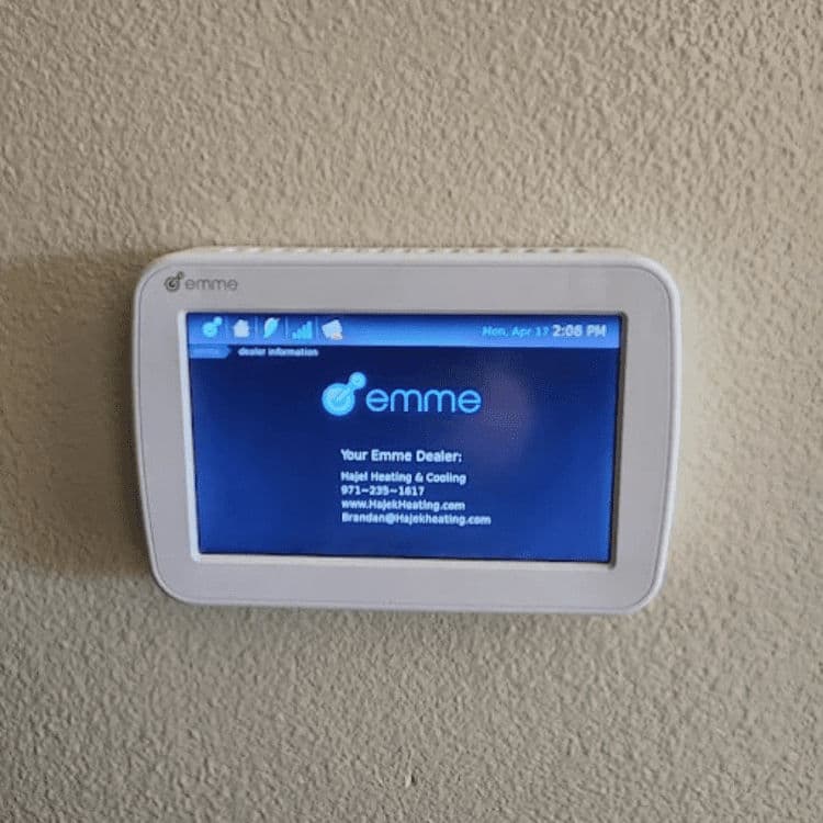 Emme smart thermostat displaying dealer information for heating and cooling services.