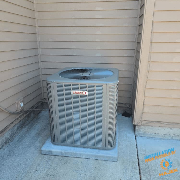 Lennox air conditioning unit installed beside a building with exterior siding.