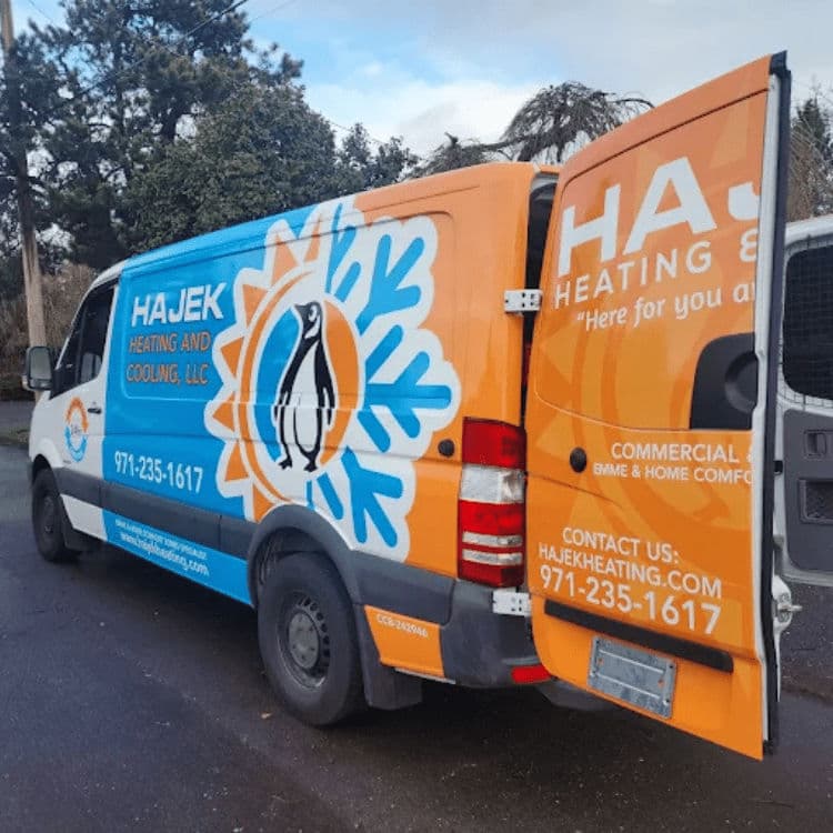 Hajek Heating and Cooling service van with colorful branding and penguin logo.