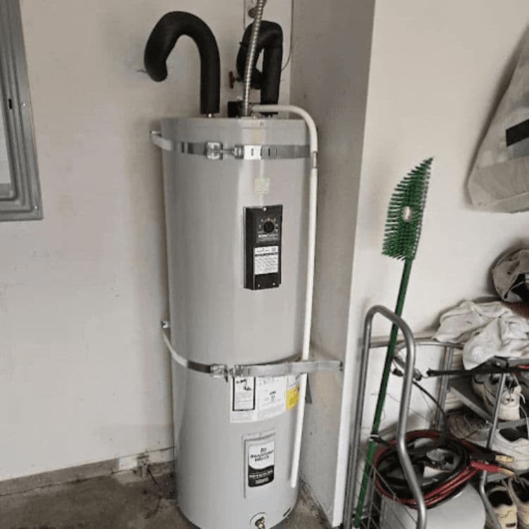 Gray water heater with pipes in a garage setting, featuring control panel and accessories.