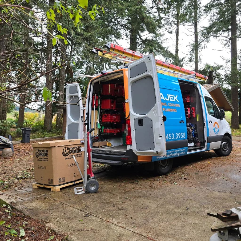 Service van for plumbing and HVAC with tools and equipment in a wooded outdoor setting.