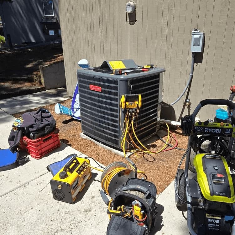 Air conditioning unit outdoors with tools and equipment for maintenance and repair.